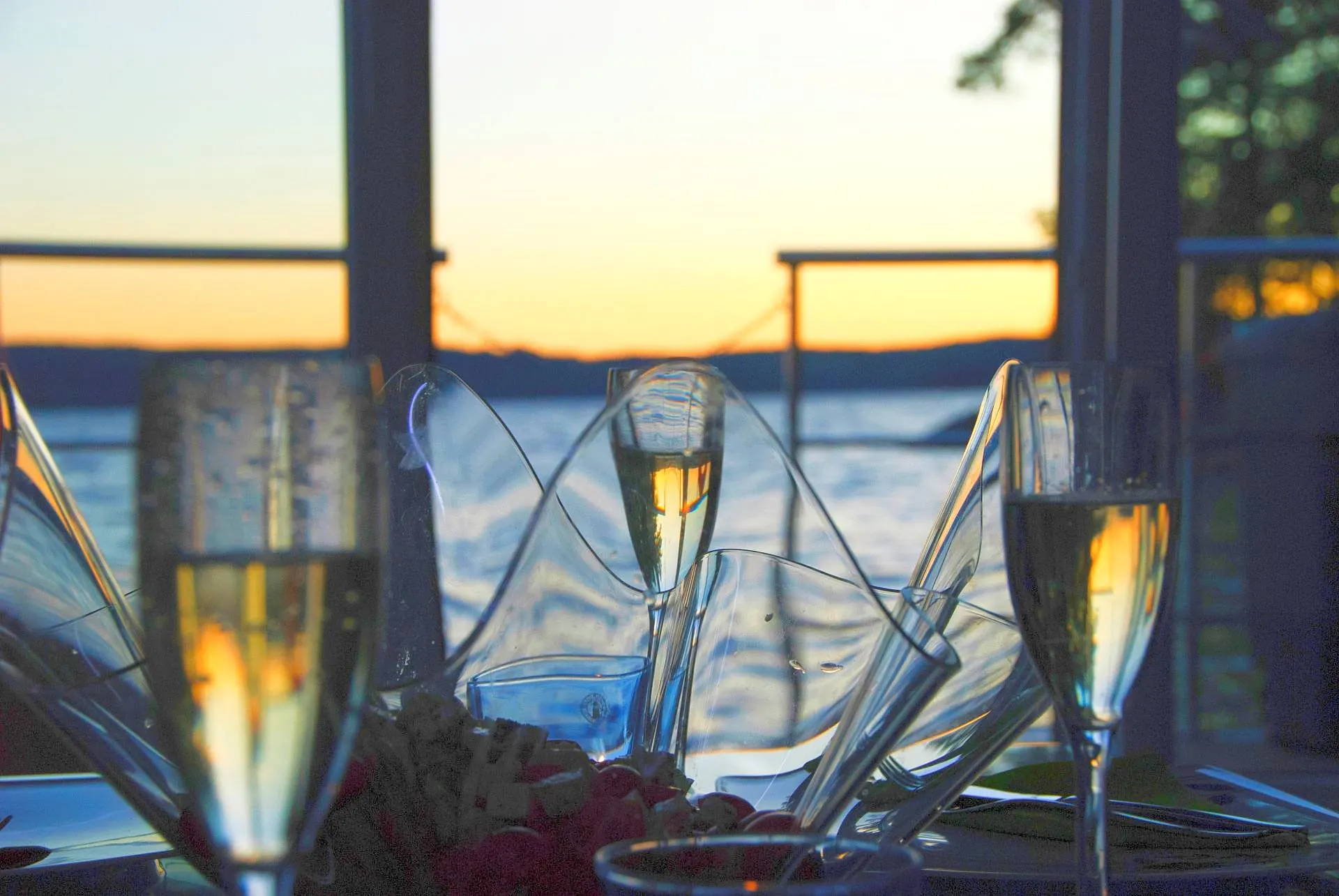 Two glasses of champagne on a table aboard a houseboat at sunset