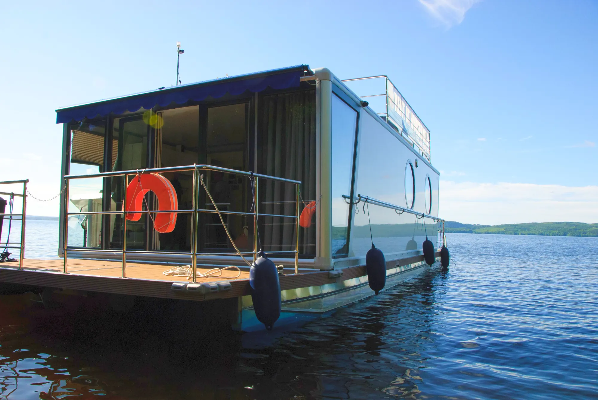 Nordic 42 Deluxe houseboat moored by a lake shore in summer